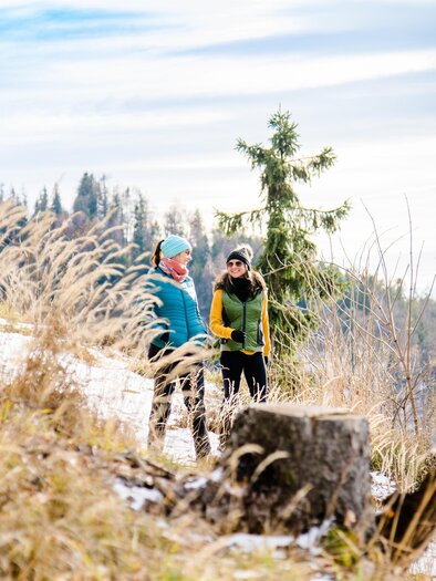 Zwei Frauen beim Winterwandern auf verschneitem Waldweg am Schöckl bei Graz. | © Region Graz-Mias Photoart