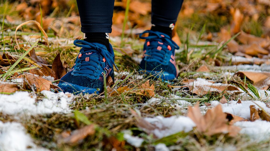 Sportliche Wanderschuhe auf laubbedecktem, leicht verschneitem Wanderweg am Schöckl bei Graz. | © Region Graz-Mias Photoart