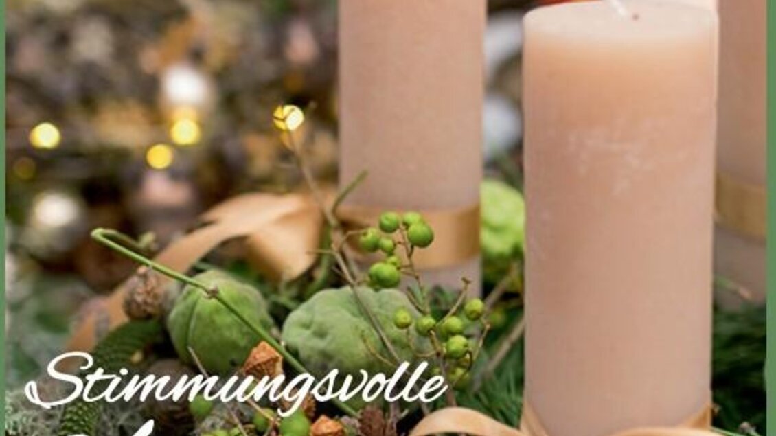 Eine festliche Adventsdekoration mit Kerzen und grünen Pflanzen. Die weiche Beleuchtung sorgt für eine gemütliche Atmosphäre. | © Blumenhof Bender