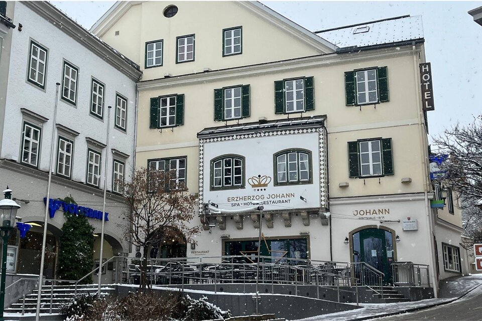 Ein historisches Gebäude mit der Beschilderung "Herzog Johann" und einem Restaurant. Im Vordergrund sind Treppen und Tische im Freien zu sehen, umgeben von einer winterlichen Landschaft. | © TVB Bad Aussee_Nathalie Schröttenhamer