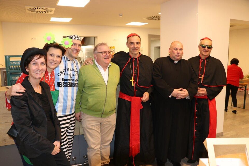 Eine Gruppe von Menschen in verschiedenen Kostümen, darunter auffällige Kleidung und schwarze Gewänder. Sie posieren fröhlich in einem Innenraum. | © Seniorenbund Bad Blumau