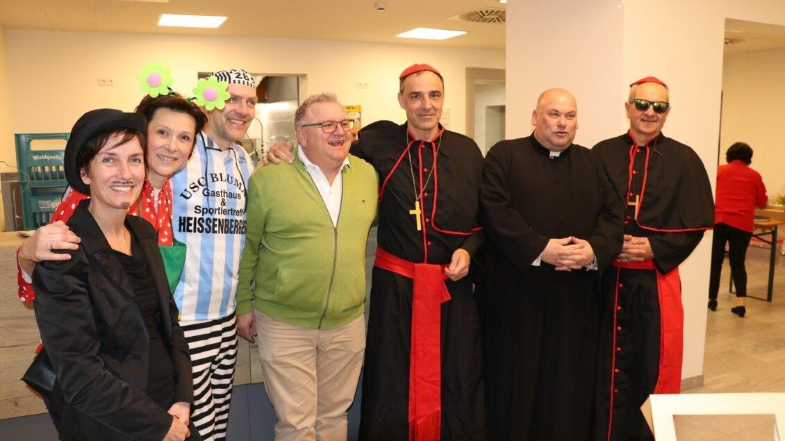 Eine Gruppe von Menschen in verschiedenen Kostümen, darunter auffällige Kleidung und schwarze Gewänder. Sie posieren fröhlich in einem Innenraum. | © Seniorenbund Bad Blumau