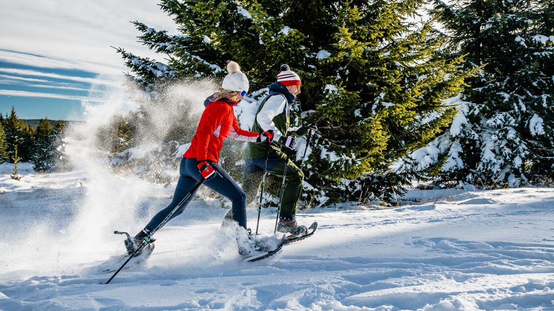Der Schnee staubt bei der flotten Schneeschuhwanderung des Paares bei herrlichen Sonnenschein.  | © Region Graz-Mias Photoart
