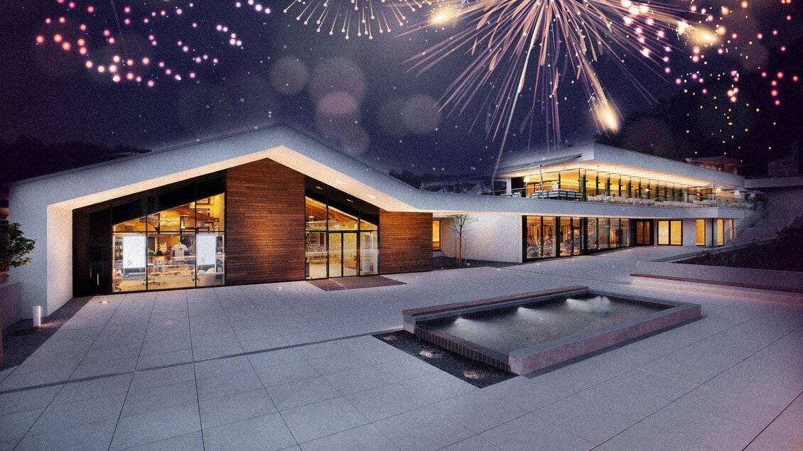 Ein modernes Gebäude bei Nacht mit einer beeindruckenden Architektur. Feuerwerkskörper erleuchten den Himmel darüber. | © (c)Heilthermen Resort Bad Waltersdorf