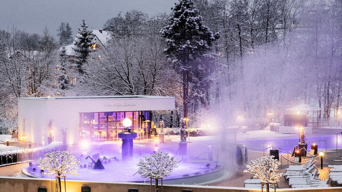Eine zauberhafte Winterlandschaft mit schneebedeckten Bäumen und einem beleuchteten Außenpool. Der Bereich strahlt eine entspannende Atmosphäre aus. | © Heilthermen Resort Bad Waltersdorf-Eisenberger