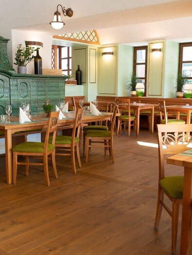 Ein elegantes Restaurant mit Holzdekor und gedecktem Tisch. Gläser und Besteck sind bereit für die Gäste. | © SPA Hotel Erzherzog Johann