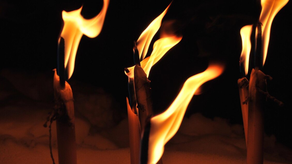 Flackernde Flammen von brennenden Kerzen vor dunklem Hintergrund. Die lodernden Flammen erzeugen eine gemütliche und warmherzige Atmosphäre. | © pixabay.com