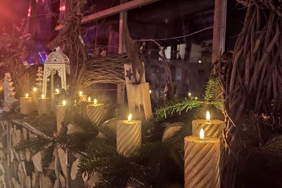 Ein festlich dekorierter Tisch mit brennenden Kerzen und einem natürlichen Arrangement aus Tannenzweigen. Die Atmosphäre ist warm und einladend. | © Stocker Peter