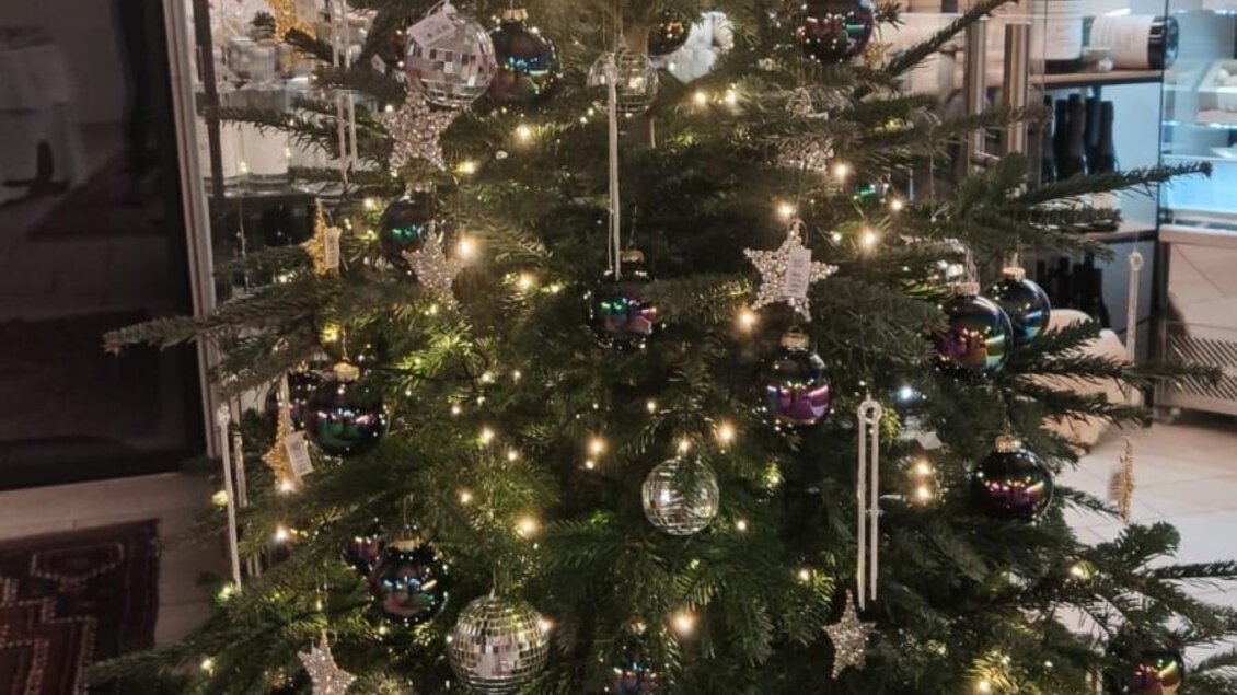 Ein geschmückter Weihnachtsbaum mit bunten Kugeln und Lichtern. Der Baum steht in einem gemütlichen Raum. | © Stocker Peter