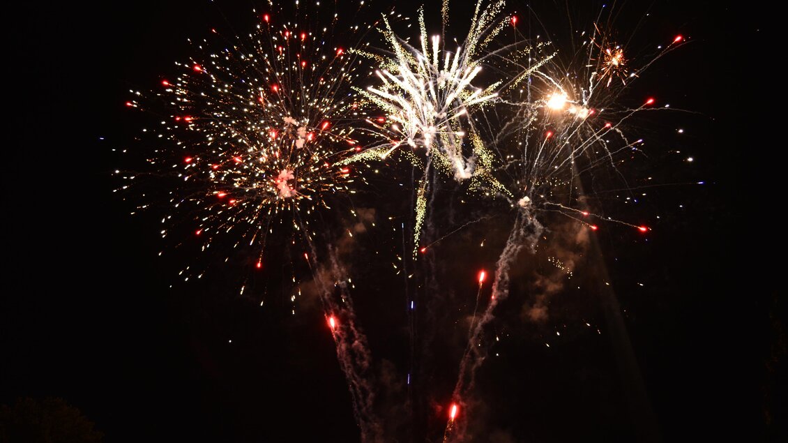 Bunte Feuerwerke erleuchten den Nachthimmel. Funken fliegen in verschiedenen Farben und Formen. | © Sandra Brünner