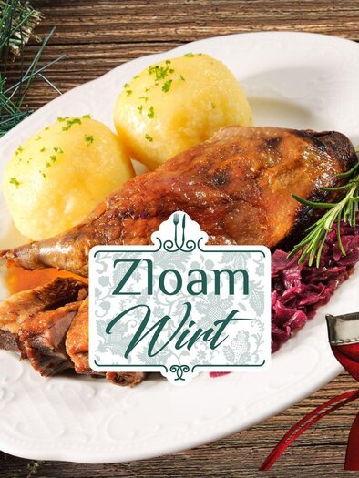 A delicious dish with roasted duck, dumplings, and red cabbage. In the background, festive decorations and the logo of "Zloaam Wirt". | © Narzissendorf Zloam