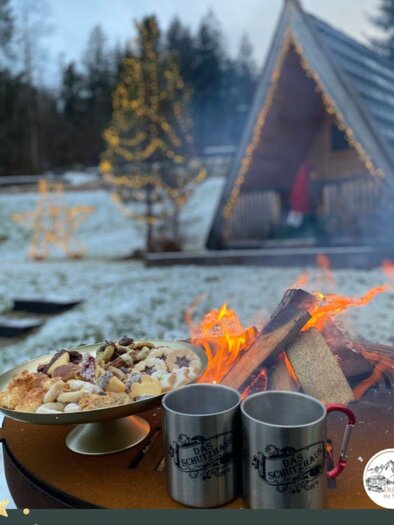 A festive scene view of a lit Christmas village with various small houses. The surroundings are decorated with artificial snow, creating a cozy atmosphere. | © Das Schutzhaus