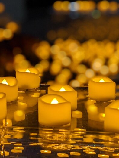 Burning candles stand on shiny parquet, it is a sea of candles that provide a warm light in the Stefaniensaal in Graz. | © DE.Light Events UG