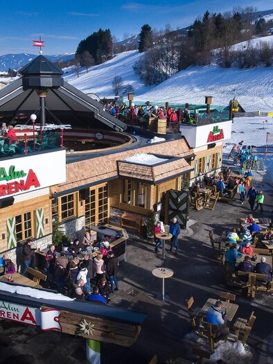 AlmArenA at the Hauser Kaibling valley station with a large sun terrace and guests enjoying après-ski in winter. | © AlmArenA