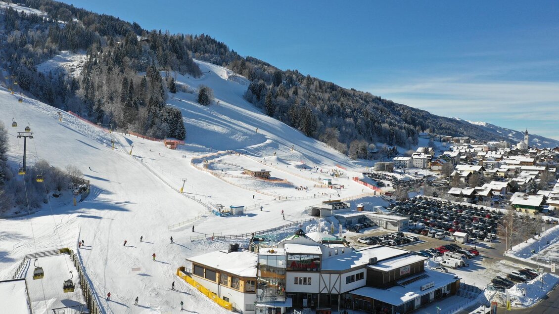 Hauser Kaibling Talstation von oben mit Drohne fotografiert. Wollis Kids Park, AlmArenA, Parkplatz, Ort Haus und 8er-Gondelbahn sind zu sehen. | © AlmArenA