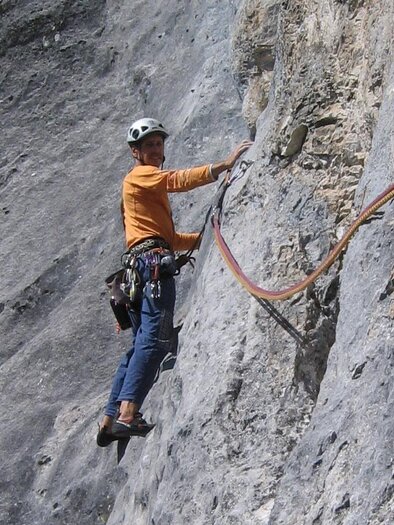 A man is climbing a steep rock face. He is wearing a helmet and is secured with climbing gear. | © Ewald Lidl