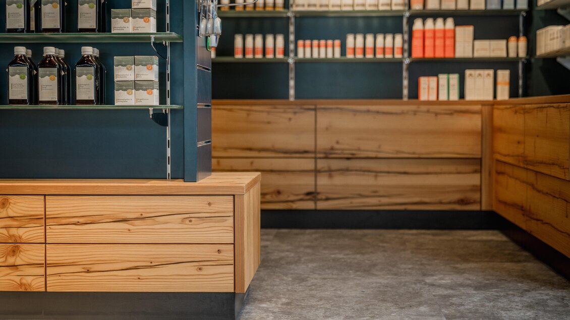 Ein stilvolles Geschäft mit Regalen voller Produkte. Der Boden ist grau, und die Möbel aus hellem Holz verleihen einen modernen Touch. | © Apotheke Planai West KG