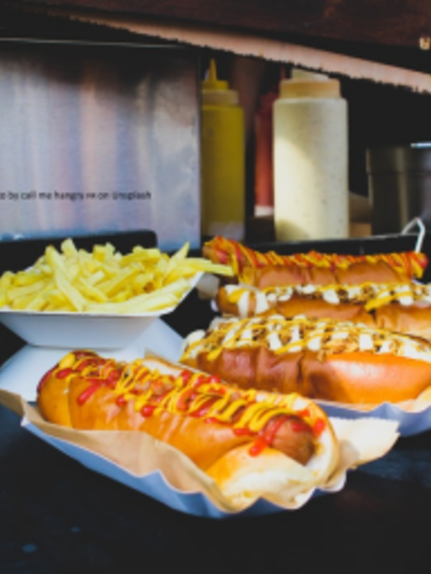 Delicious hotdogs with mustard and ketchup, served with French fries. Next to it is a can of Coca-Cola. | © Arno's Futtertrog