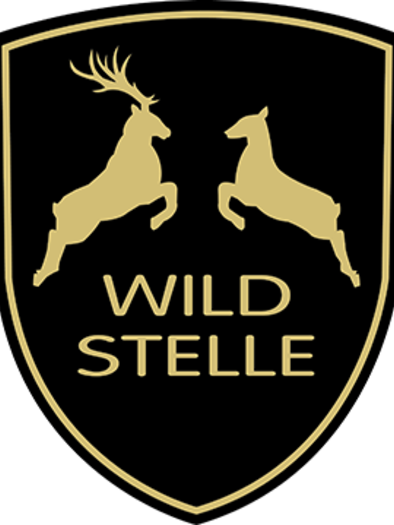 Ein stilisiertes Wappen mit zwei springenden Tieren, einem Hirsch und einem Reh. Der Text "WILD STELLE" ist in der Mitte platziert. | © Atelier Wildstelle