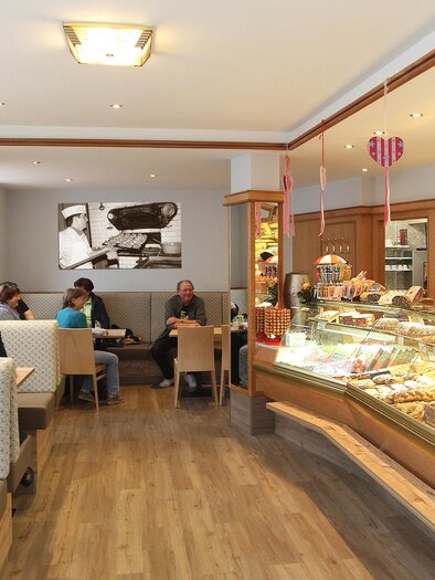 Inviting café with a selection of pastries and snacks. Guests sit comfortably and enjoy the atmosphere. | © Foto Tom