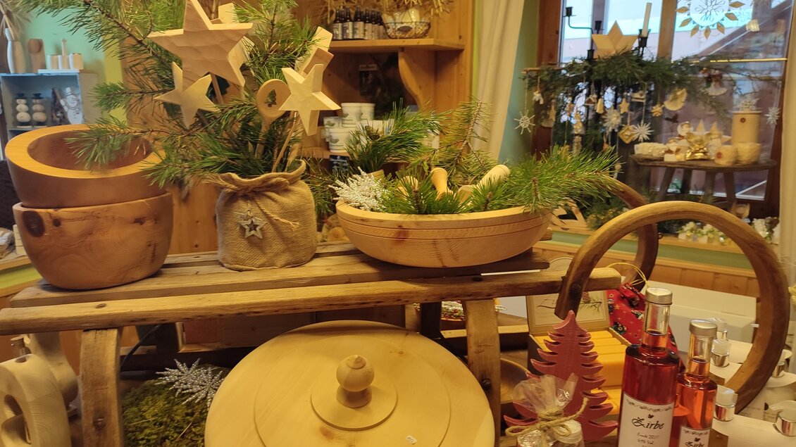Ein einladendes Geschäft mit Holzschüsseln, dekorativen Elementen und Pflanzen. Sanfte Weihnachtsdekoration sorgt für eine gemütliche Atmosphäre. | © Bauernladen Gröbming