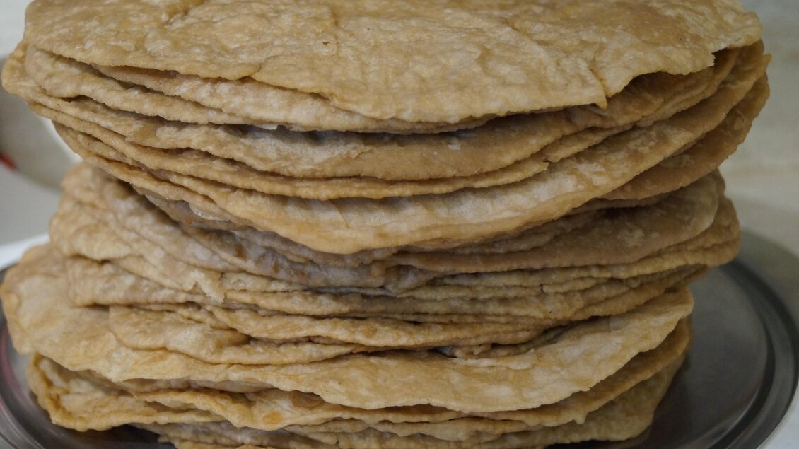 Ein Stapel frisch gebackener Fladenbrote liegt auf einer silbernen Platte. Die Brote haben eine goldene Farbe und sind leicht knusprig. | © Marianne Ritzinger 