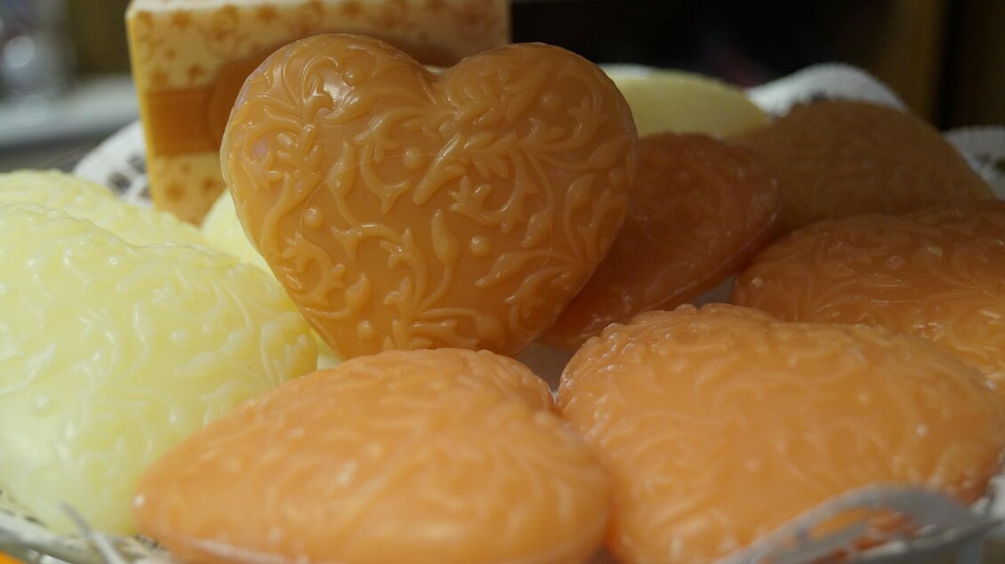 Eine Auswahl an handgemachten Seifen in Herzform. Die Seifen sind in verschiedenen Farben und mit dekorativen Mustern verziert. | © Marianne Ritzinger 