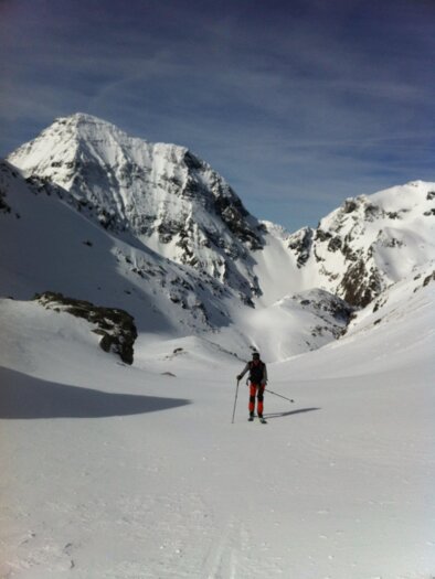 A skier stands in a snow-covered mountain landscape. The majestic mountains are visible in the background. | © Monte-Krah