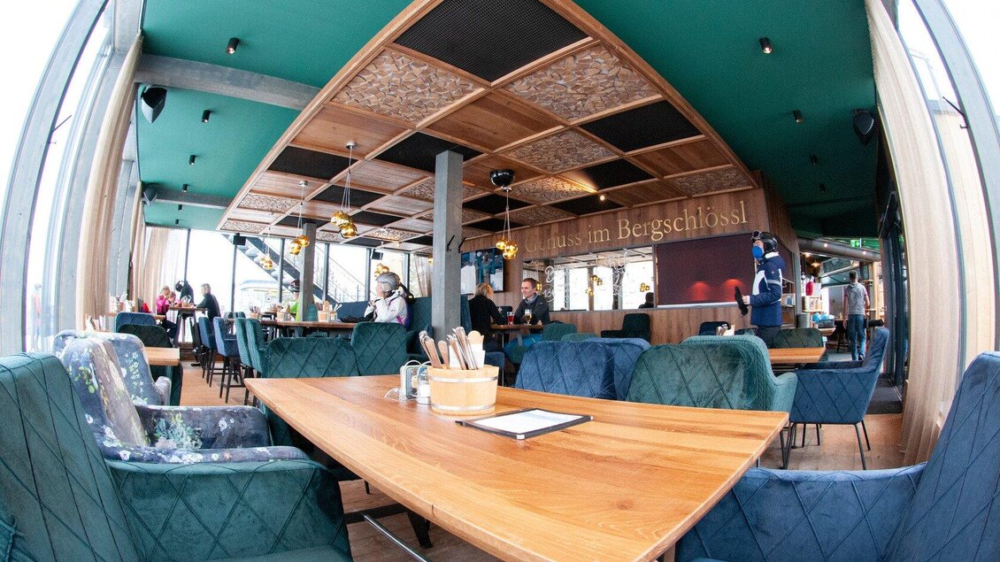 Ein modernes Restaurant mit einem einladenden Innenraum. Große Fenster bieten einen Blick nach draußen und die Einrichtung ist stilvoll und gemütlich. | © Knappl's Bergschlössl