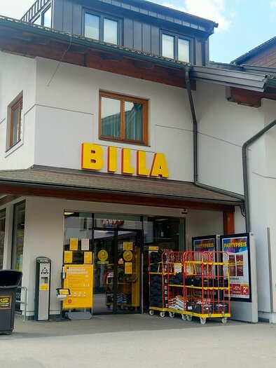 A supermarket named "BILLA" at the front. The facade is modern and bright, surrounded by a parking lot. | © Tourismusverband Schladming