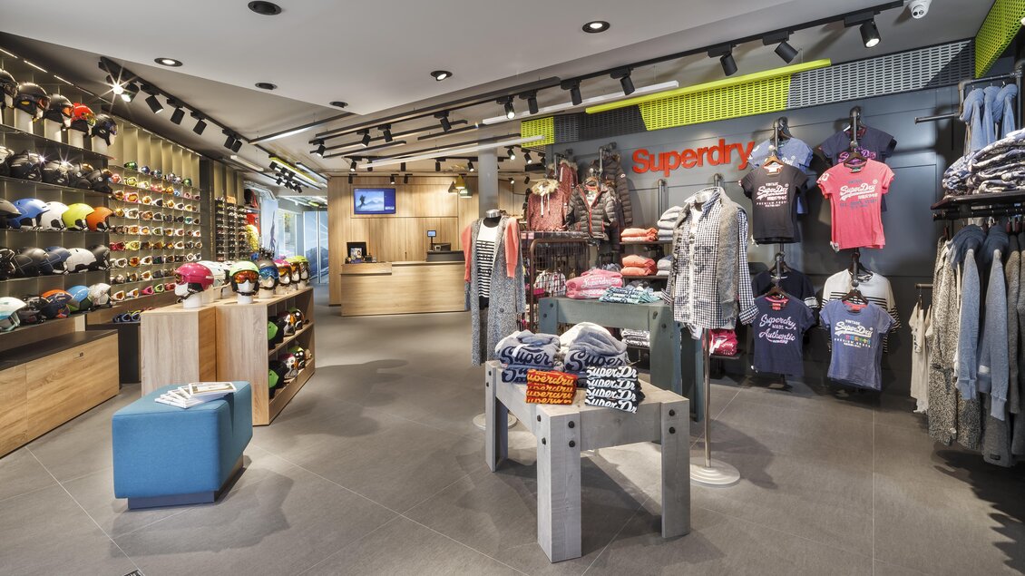 Ein moderner Einzelhandelsladen mit einer Vielzahl von Kleidung und Accessoires. Regale sind gut organisiert und bieten eine einladende Atmosphäre. | © Bründl Sports / Christian Wöckinger