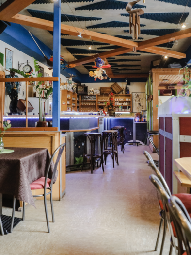 Ein gemütliches Restaurant mit Holzdekor und einer bunten Atmosphäre. Tische sind ordentlich gedeckt, und Pflanzen verleihen dem Raum Leben. | © Cafe Pub Harlekin