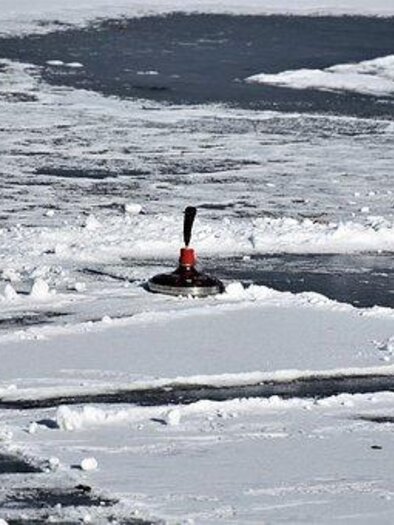 Ein Curlingstein liegt auf einer gefrorenen Fläche mit Schneeresten. Die Umgebung ist winterlich und zeigt glatte Eisflächen. | © Symbolfoto