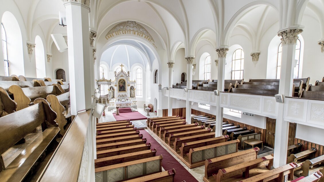 Eine große Kirche mit hohen Decken und vielen Holzbänken. Im Hintergrund ist der Altar gut sichtbar. | © Gerhard Pilz