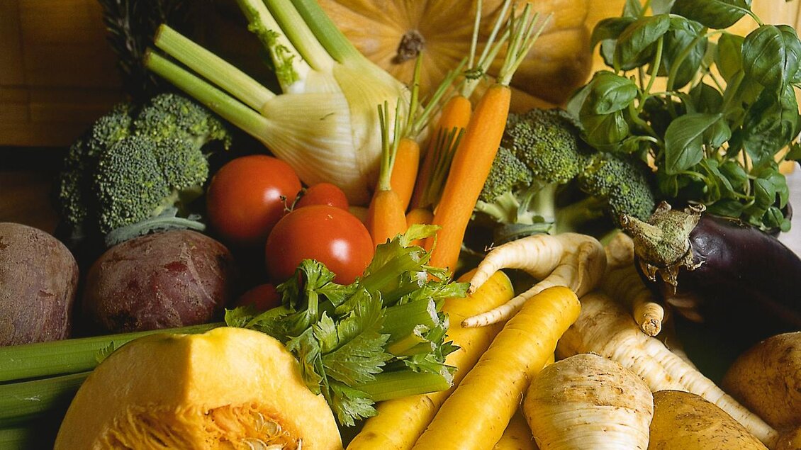Eine Vielzahl frischer Gemüse, darunter Kürbis, Brokkoli, Karotten und Tomaten, liegt schön auf einem Holzbrett. Die bunten Farben und die verschiedenen Formen bieten ein appetitliches Bild. | © Hotel Spanberger 