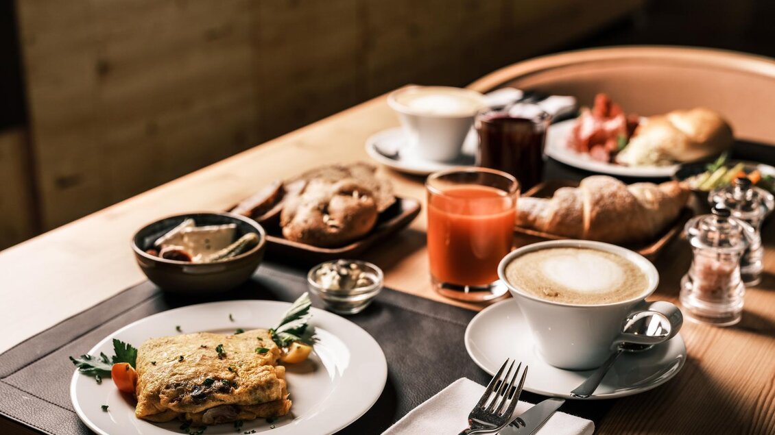 Ein reichhaltiges Frühstücks-Arrangement mit einer Omelette, frischem Brot, Kaffee und Saft. Die Atmosphäre ist gemütlich und einladend. | © Falkensteiner Hotels &amp; Residences / Fotograf Dragan Dokmanovic
