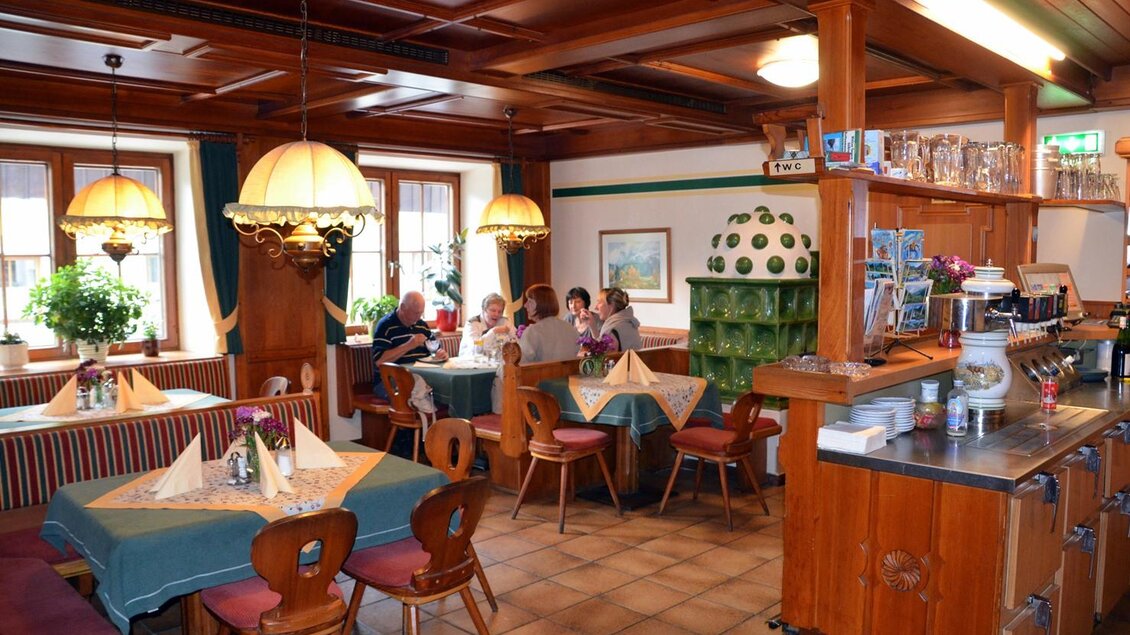 Ein gemütliches Restaurant mit Holzdetails und warmem Licht. Gäste sitzen an Tischen und genießen ihre Mahlzeiten in einer einladenden Atmosphäre. | © Christian Tritscher