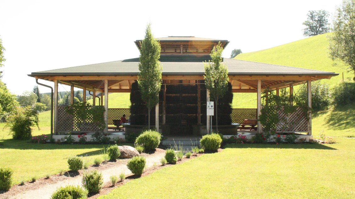 Ein schönes Holzgebäude mit einem begrünten Dach und großen Fenstern. Umgeben von gepflegten Rasenflächen und Bäumen. | © Infobüro Gröbming