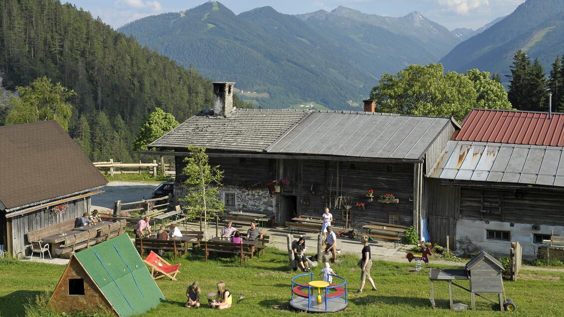 Einige Kinder, welche im Garten einer Alm spielen im Sommer. | © Halseralm