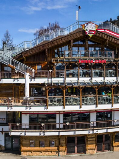 A cozy holiday home in the mountains with a view of a ski slope. The surroundings are snow-covered and the sky is blue with some clouds. | © AIR-Media.at