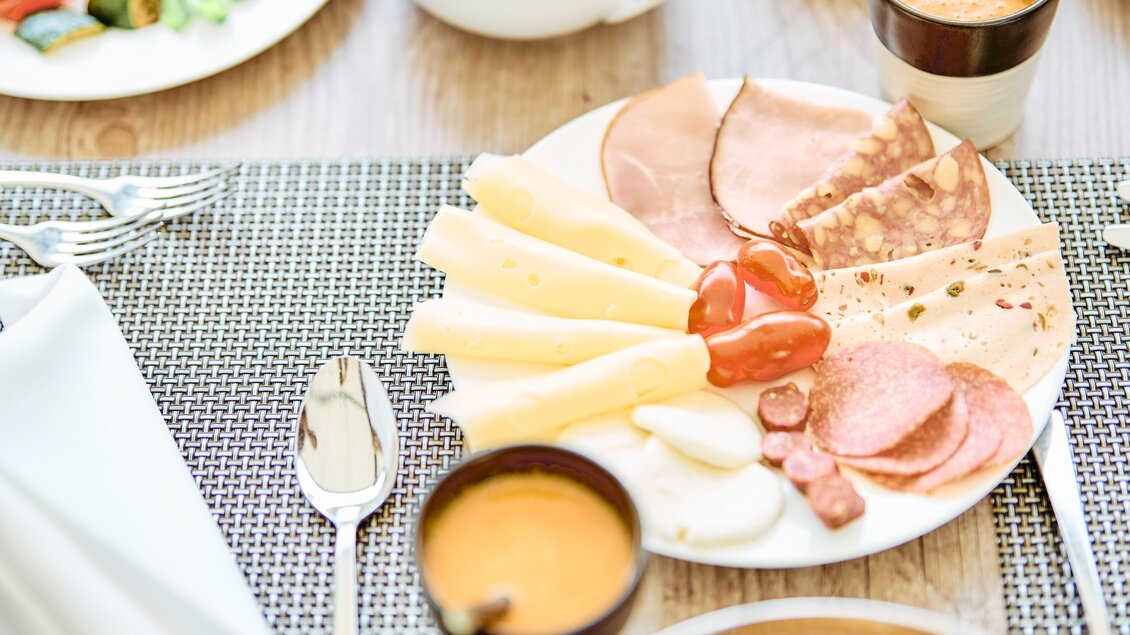 Ein reichhaltiges Frühstück mit Wurst, Käse und frischem Obst. Dazu gibt es Kaffee und Gebäck auf einem schön gedeckten Tisch. | © Thomas Sattler