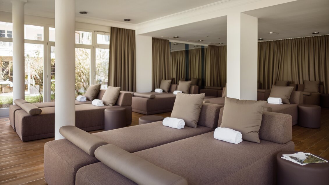Ein moderner und entspannender Raum mit bequemen Liegen und großen Fenstern. Die samtigen Vorhänge schaffen eine ruhige Atmosphäre. | © Richard Schabetsberger