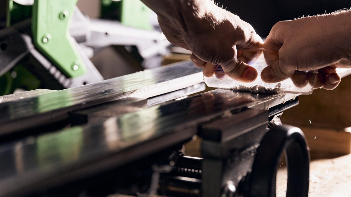 Zwei Hände arbeiten an einer Maschine. Holz wird präzise bearbeitet. | © Intersport Gerhardter