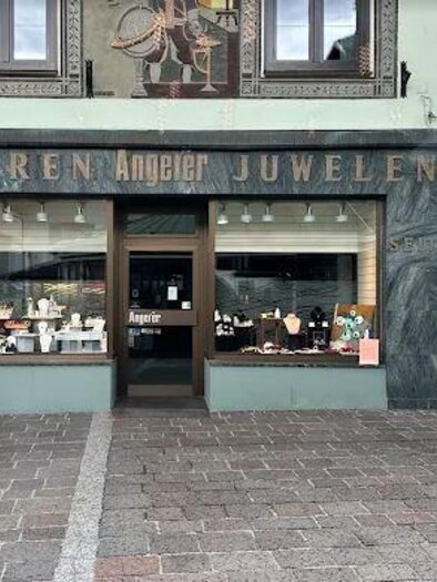 Ein Schmuckgeschäft mit der Aufschrift "Uhren Angler Juwelen" in einem historischen Gebäude. Die Schaufenster zeigen eine Vielzahl von Uhren und Schmuckstücken. | © Juwelier Angerer