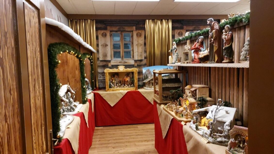 Ein festlich dekorierter Raum mit Weihnachtskrippen und Figuren. Die Wände sind mit Holz verkleidet und es gibt weihnachtliche Beleuchtung. | © Gerald Gerhardter