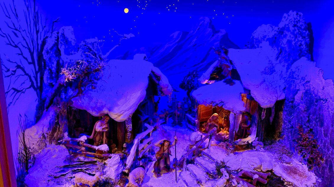 Eine winterliche Szene mit zwei Hütten im Schnee. Die Umgebung ist mit Bäumen und einem klaren Nachthimmel dekoriert. | © Gerald Gerhardter