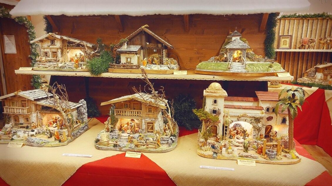 Eine festliche Dekoration mit mehreren kunstvoll gestalteten Krippen. Die Szenen zeigen verschiedene Gebäude und Figuren in weihnachtlicher Atmosphäre. | © Gerald Gerhardter