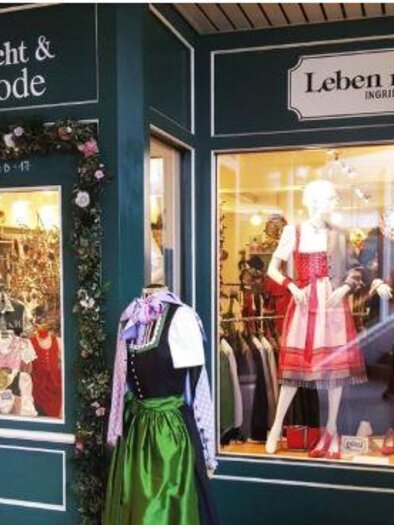 A store for traditional clothing with windows showcasing traditional garments. The decoration is appealing and conveys a sense of tradition. | © Leben mit Tradition