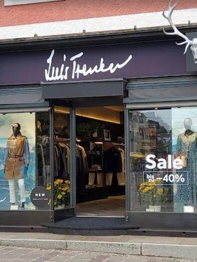 A clothing store with display windows showcasing elegant clothing. There is a special offer of 40% off. | © Felix Hagemann