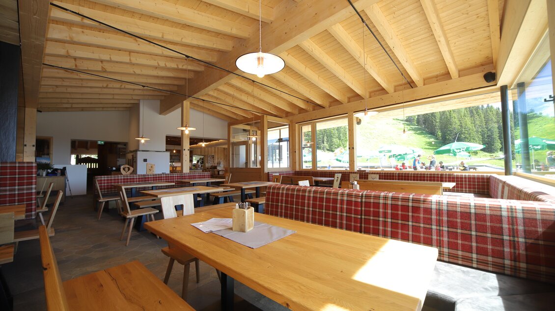 Ein modernes Restaurant mit Holzdecke und großen Fenstern. Die Einrichtung ist gemütlich mit Holztischen und einladenden Bänken im Innenbereich. | © Gerald Petter
